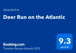 Blue graphic displaying "Awarded to Deer Run on the Atlantic" with a 9.3 out of 10 rating, and "Booking.com Traveller Review Awards 2025" written at the bottom.